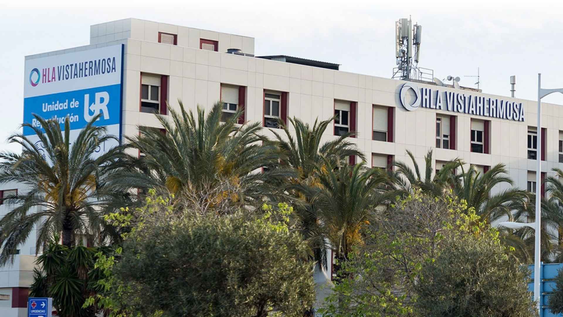 Esterno della clinica UR Vistahermosa ad Alicante con edificio principale circondato da palme.