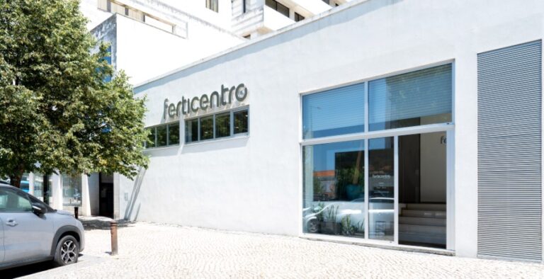 Vista esterna della moderna clinica di fertilità Ferticentro a Coimbra con edificio bianco, ingresso vetrato e logo sulla facciata.